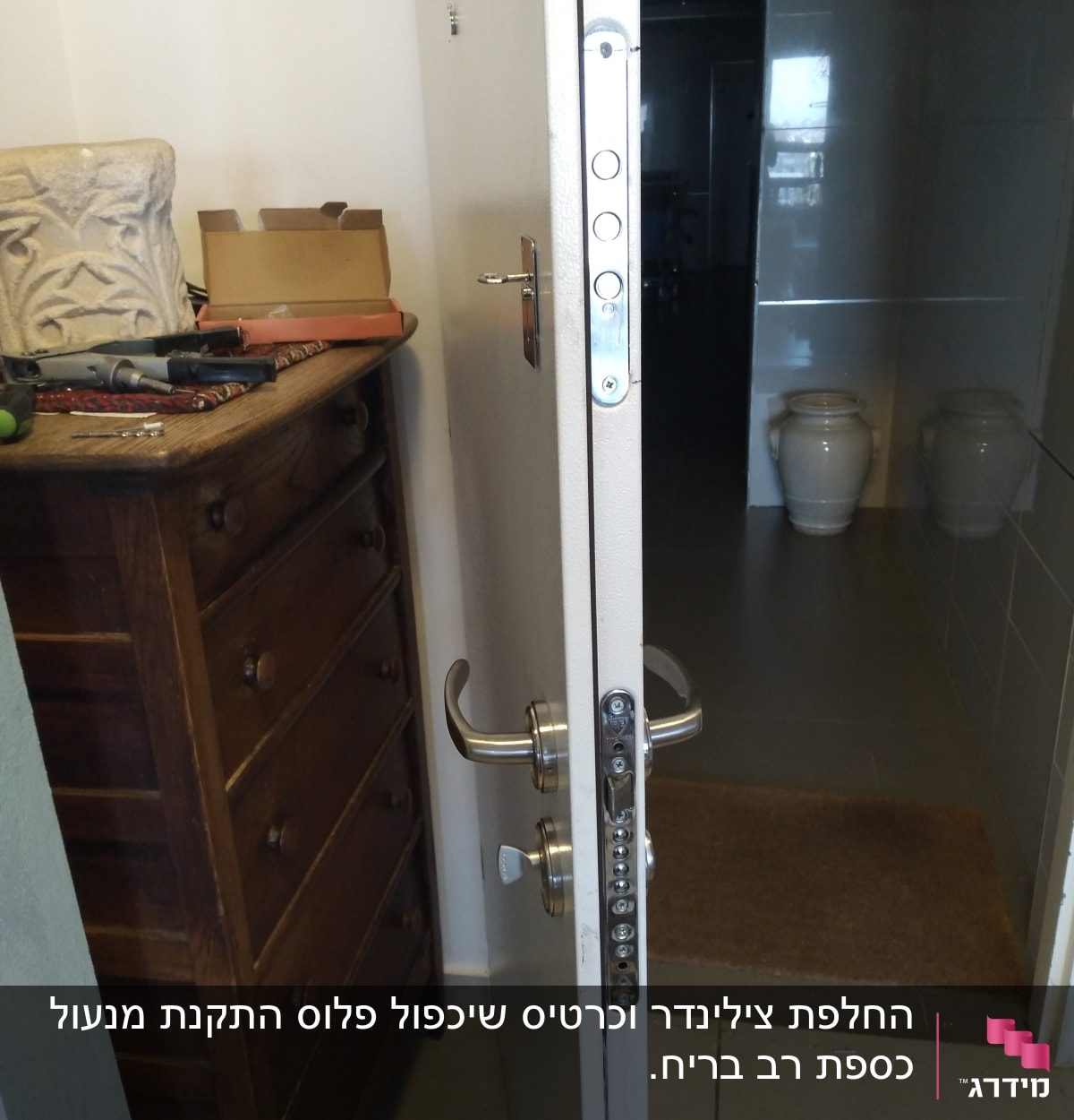 דלת פתוחה עם מנעול ומברגים על שידה